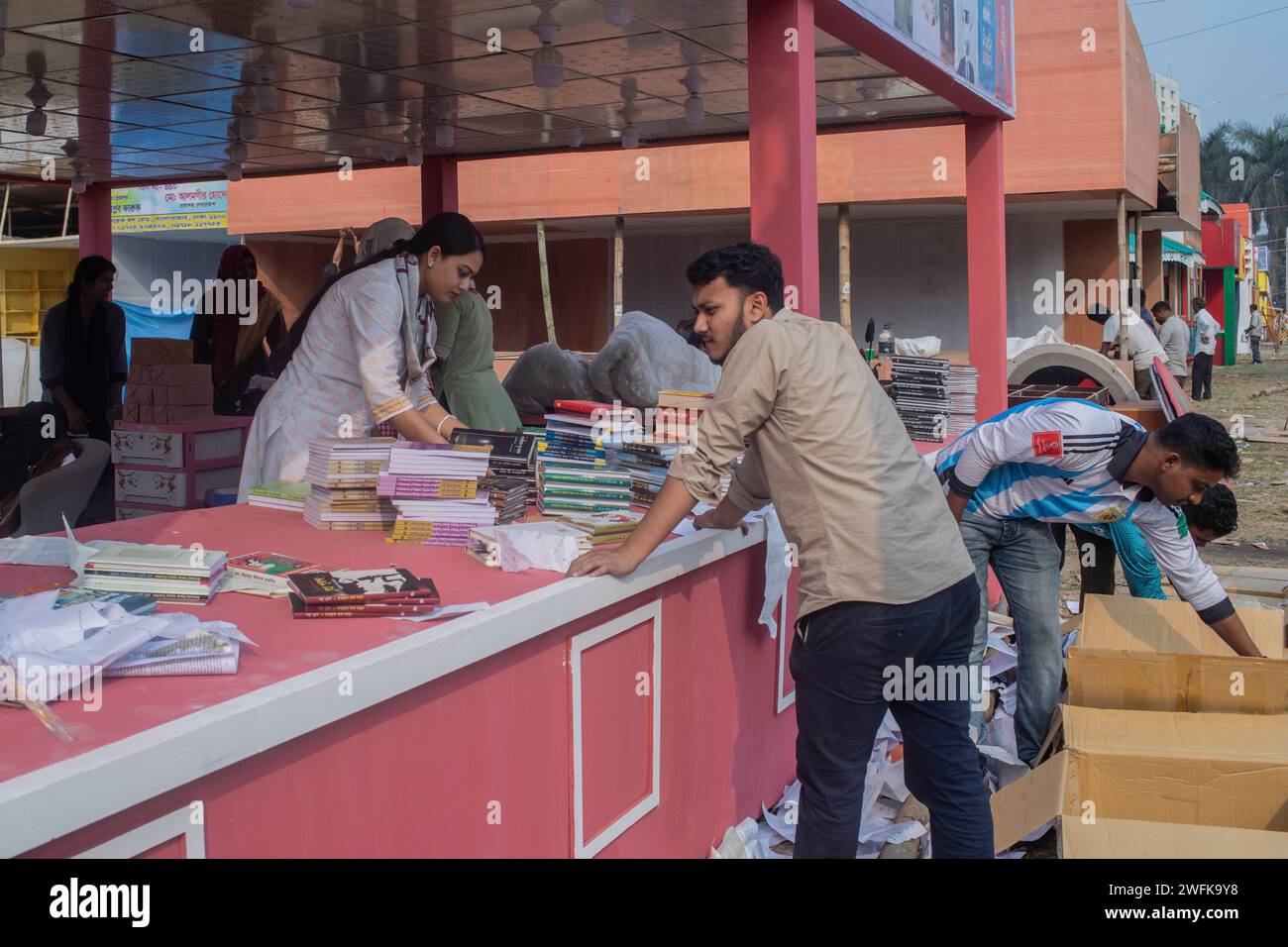 Ein Mädchen arrangiert Bücher an einem Stand der Amar Ekushey Buchmesse in Dhaka's Suhrawardy Udyan. Stockfoto