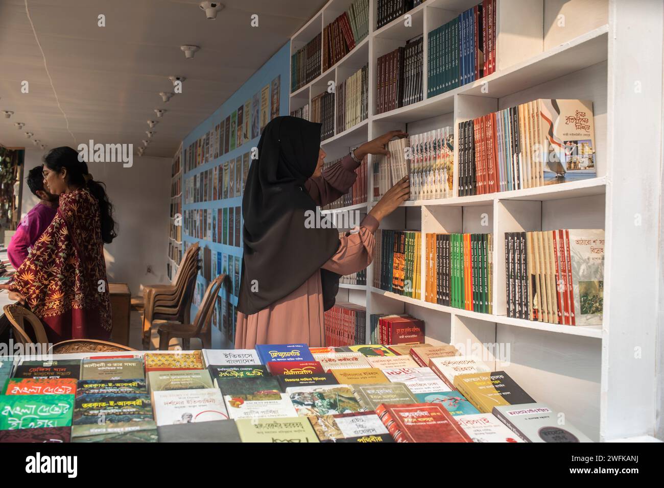 Dhaka, Bangladesch. Januar 31, 2024. Ein Mädchen arrangiert Bücher an einem Stand vor der Amar Ekushey Buchmesse in Dhaka's Suhrawardy Udyan. (Foto: Sazzad Hossain/SOPA Images/SIPA USA) Credit: SIPA USA/Alamy Live News Stockfoto