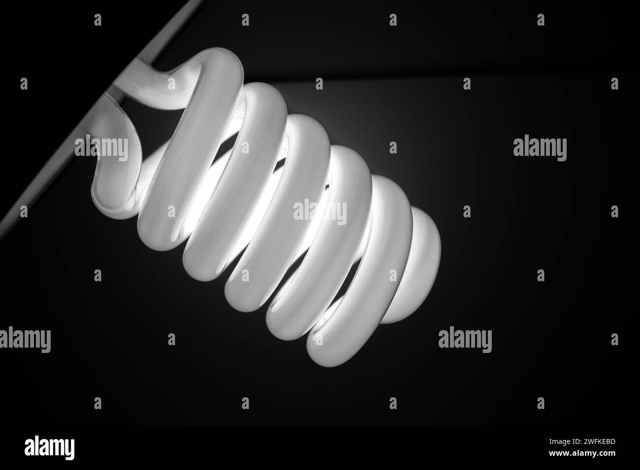 Weiße spiralförmige Fotolampe. Schwarzer Hintergrund. Stockfoto