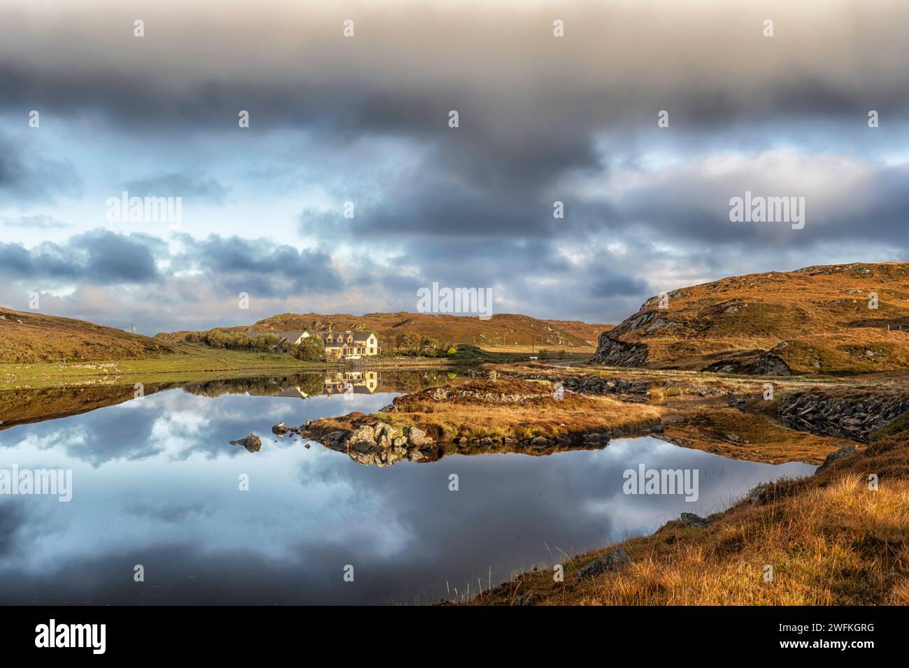 Das Doune Braes Hotel in der Township Carloway spiegelt sich in den ruhigen und stillen Gewässern von Loch an Dunain auf der Isle of Lewis in den Äußeren Hebriden wider. Stockfoto
