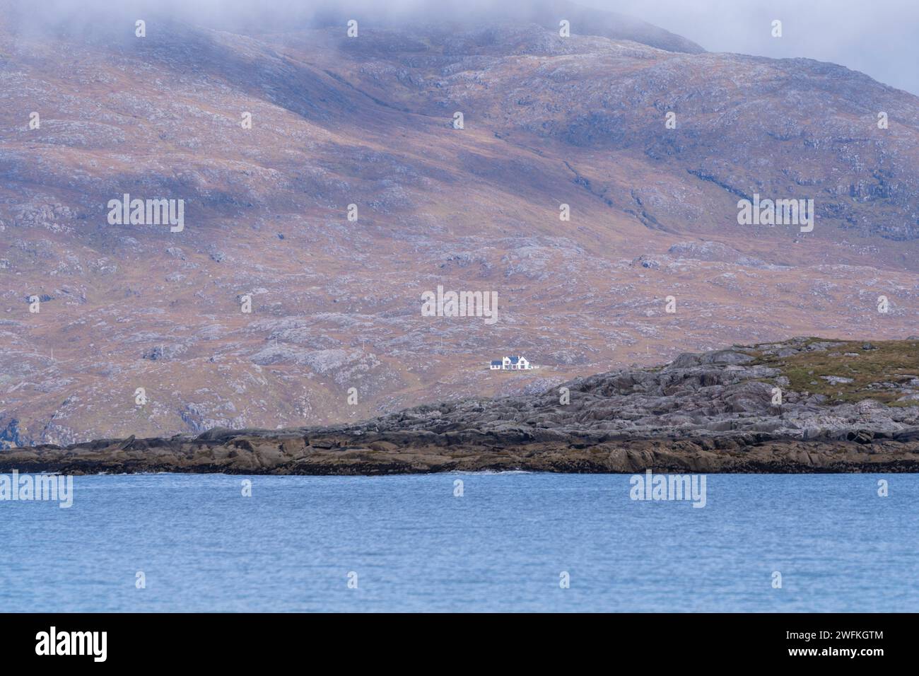 Magische Aussicht vom Strand Luskentyre auf ein einsames Haus in den Bergen um Cliasmol. Stockfoto