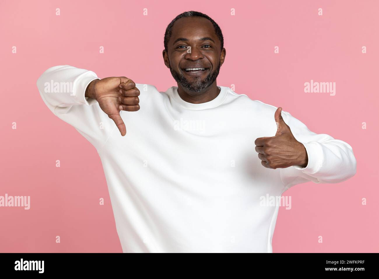 Ein lächelnder schwarzer Mann mit weißem Sweatshirt zeigt Gesten wie und Abneigung Stockfoto