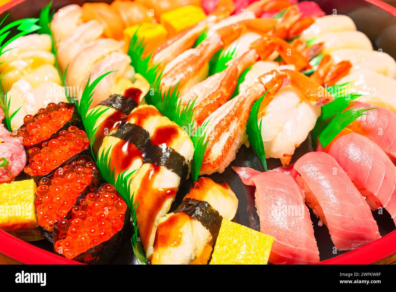 Handgepresstes Nigirizushi mit japanischen Meeresfrüchten, einschließlich Anago Congridae, Krabbenbeinen, Garnelen, mittelfettem Chūtoro-Thunfisch und Gunkanmaki gefüllt mit i Stockfoto