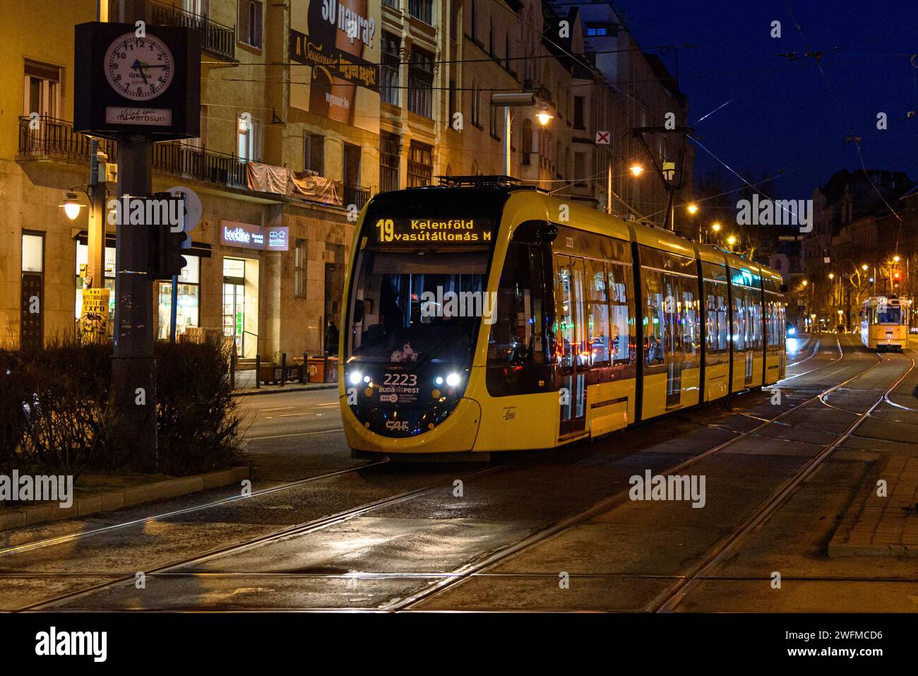 Eine CAF Urbos 3-Straßenbahn auf der Linie 19 am Moricz Zsigmond Korter in Budapest bei Nacht im Winter Stockfoto