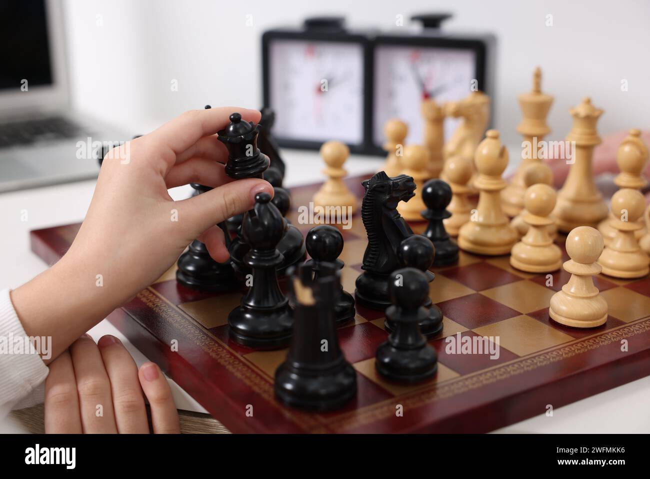 Kleines Kind, das Schach am Tisch spielt, Nahaufnahme Stockfoto