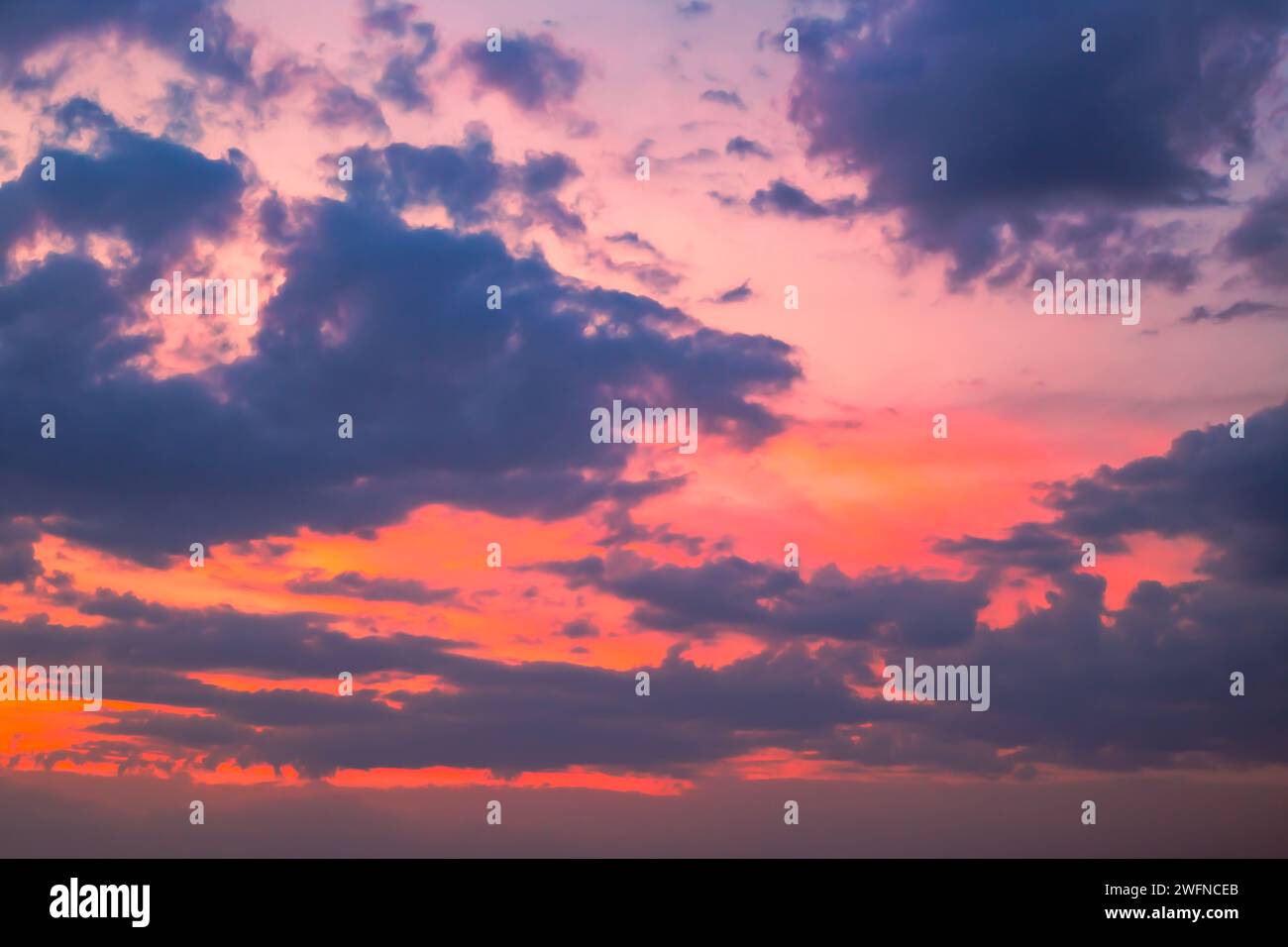 Dunkler Himmel mit hellen Wolken bei Sonnenuntergang. Abendlicher Himmelhintergrund, dramatische Himmelslandschaft. Stockfoto