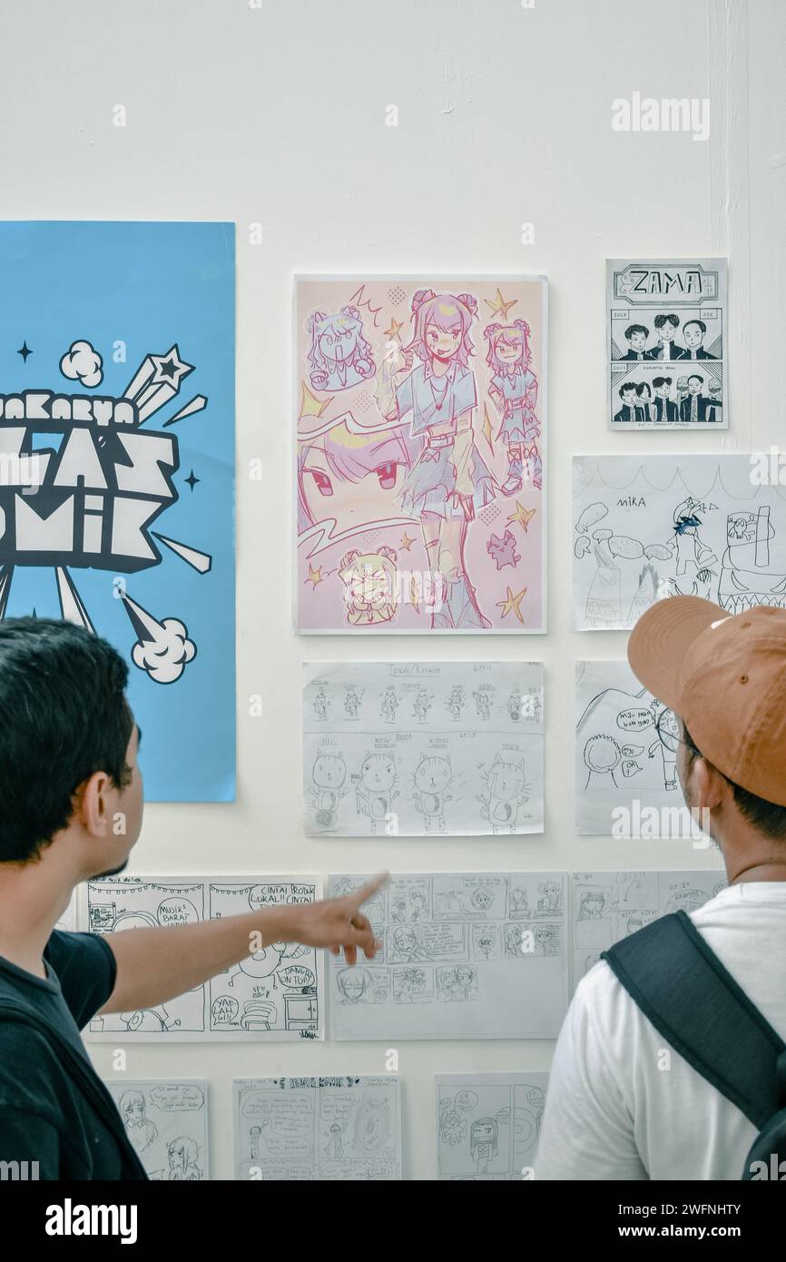 Zwei Leute schauen sich eine Comic-Galerie-Ausstellung an Stockfoto
