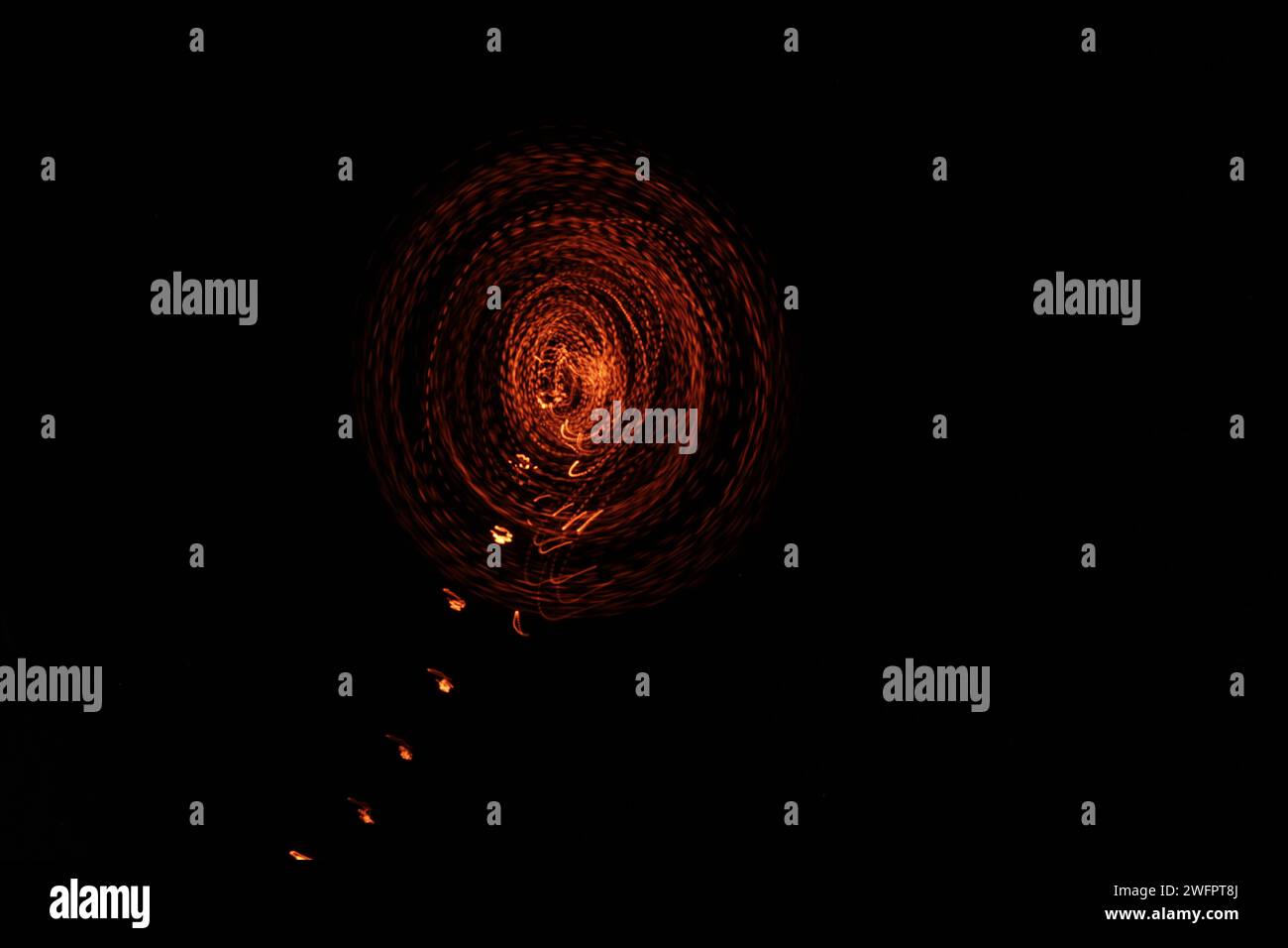 Stellen Sie sich in einem experimentellen und künstlerischen Abenteuer eine Szene vor, in der Feuerkreise durch Langzeitbelichtung ein feuriges, gepunktetes Erscheinungsbild annehmen Stockfoto
