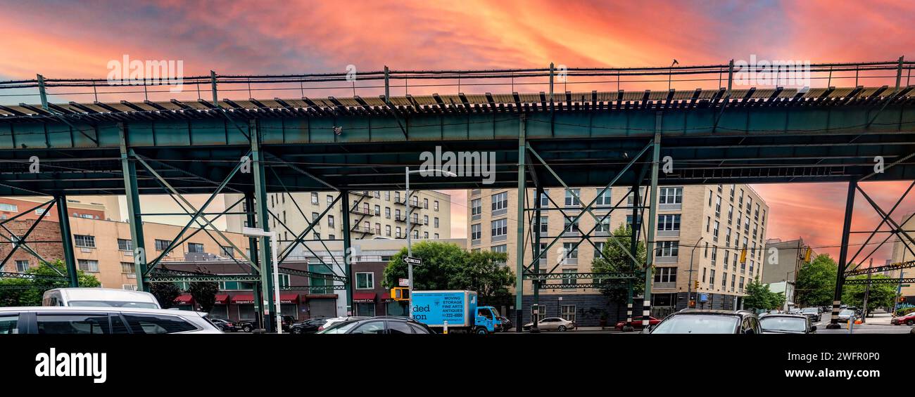 Typische Oberbahn- und U-Bahn-Gleise der Bronx, einem Viertel im Big Apple, unter einem wunderschönen orangefarbenen Himmel. Stockfoto