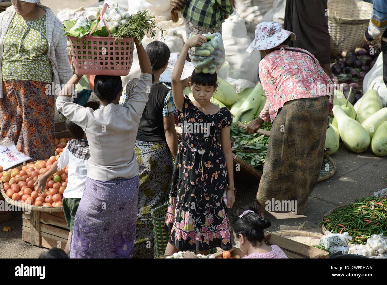 22/2014 - Yangon, Myanmar: Menschen kaufen und verkaufen frisches Gemüse auf einem belebten Freiluftmarkt in Yangon, Myanmar, mit Schwerpunkt auf traditionellem Gemüse Stockfoto
