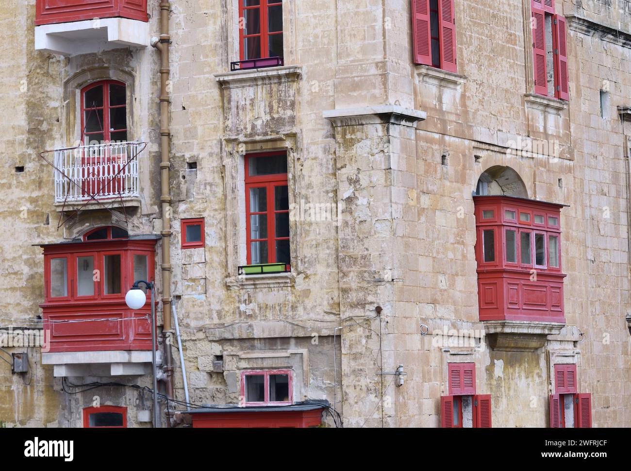 Eine Fassade eines Gebäudes in Malta, geschmückt mit traditionellen maltesischen Balkonen in rot bemalt Stockfoto