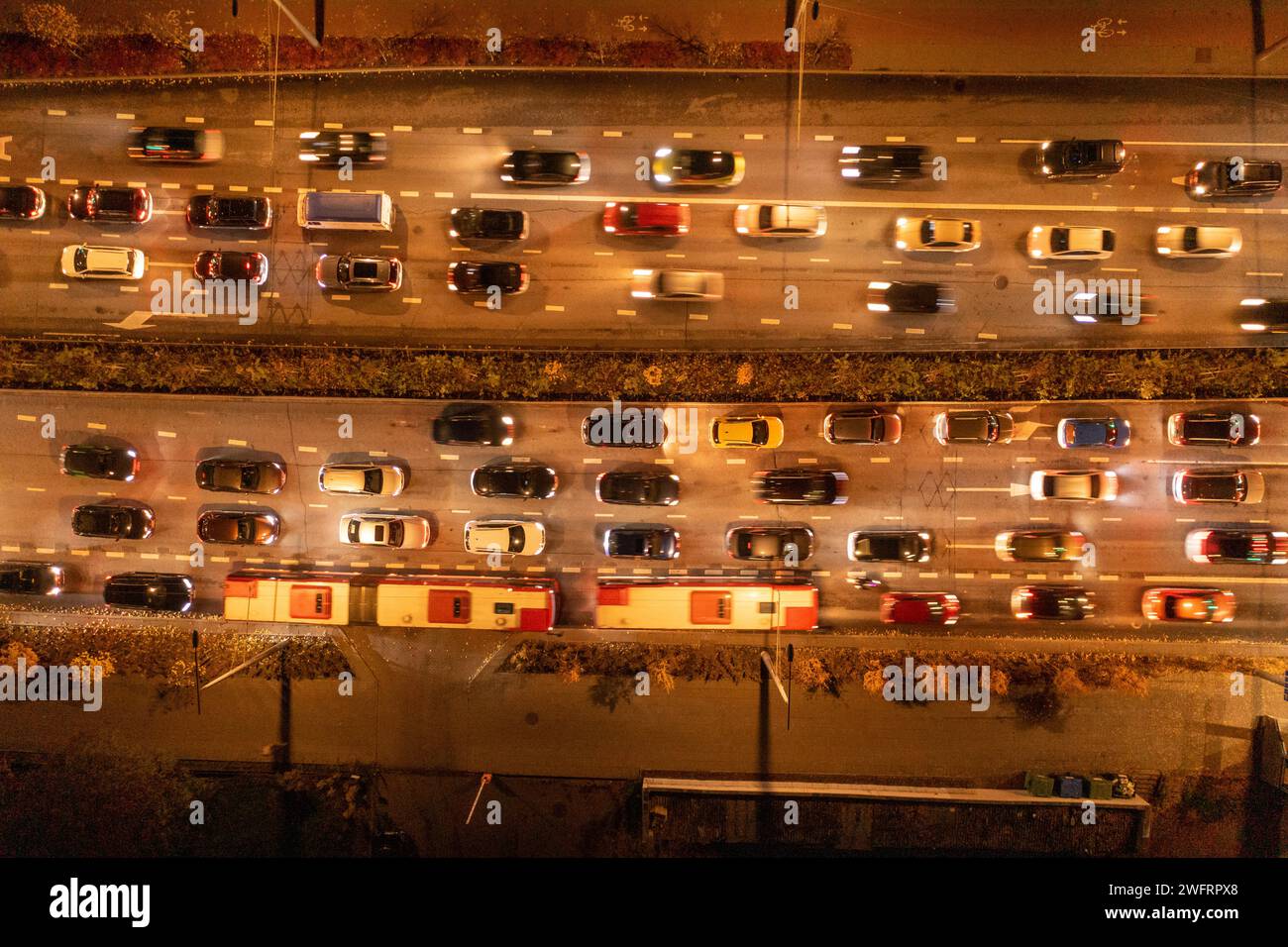 Drohnenfotografie von oben nach unten auf die Hauptverkehrszeit der Stadt während der bewölkten Herbstnacht Stockfoto