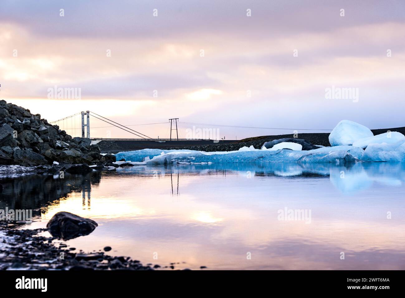 Gefrorenes Wasser mit schwimmendem Eis und einer fernen Brücke Stockfoto