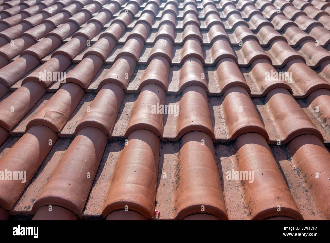 Hintergrundstruktur der Dachziegel. Braunes Wellblechelement, traditionelles griechisches Hausdach im Sonnenlicht. Wasserdichter Schutzton. Kopierbereich Stockfoto