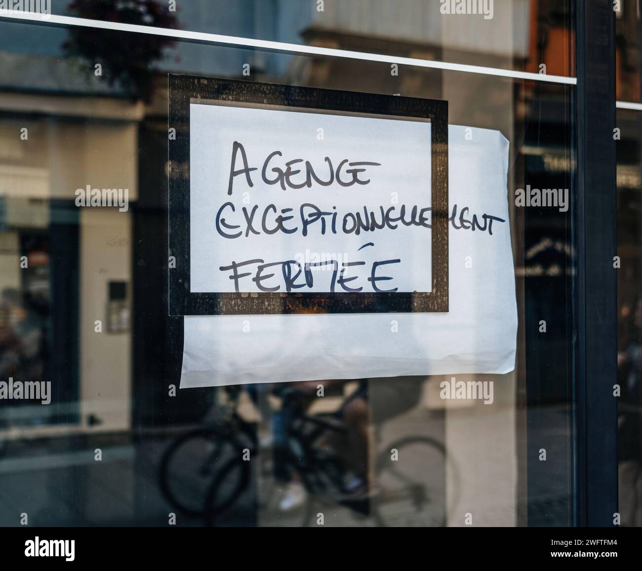 Eine Mitteilung in französischer Sprache an der Glastür, die die Schließung einer Agentur vorsieht Stockfoto