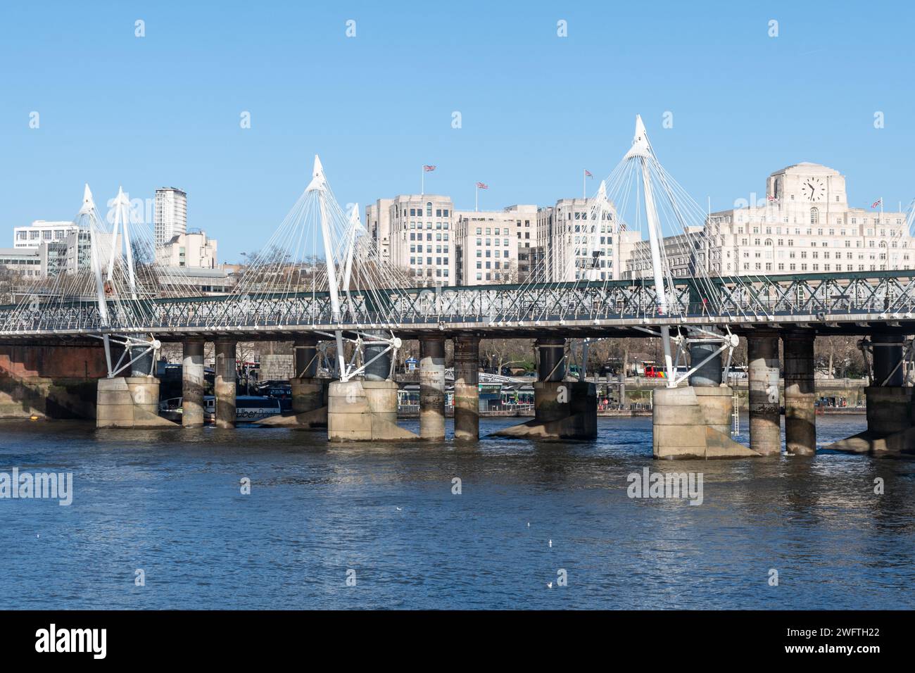 Blick auf die Hungerford Bridge und die Golden Jubilee Steps über die Themse in London an einem sonnigen Wintertag in England, Großbritannien Stockfoto
