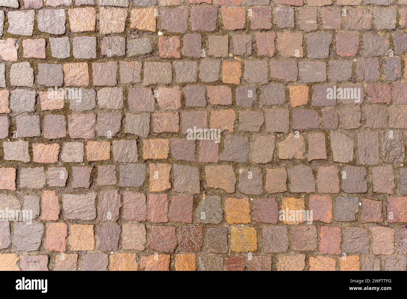 Textur des Gehweges von oben gesehen. Alte unregelmäßige Steine werden verwendet. Stockfoto