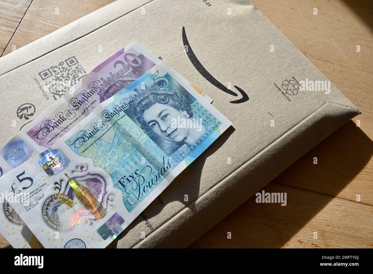 Amazon-Paket und Sterling-Bargeld (5- und 20-Pfund-Scheine). Stockfoto