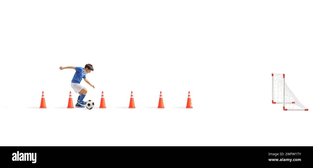 Aufnahme in voller Länge eines Jungen in einem blauen Trikot Trainingsfußball mit Kegel-Hindernissen isoliert auf weißem Hintergrund Stockfoto