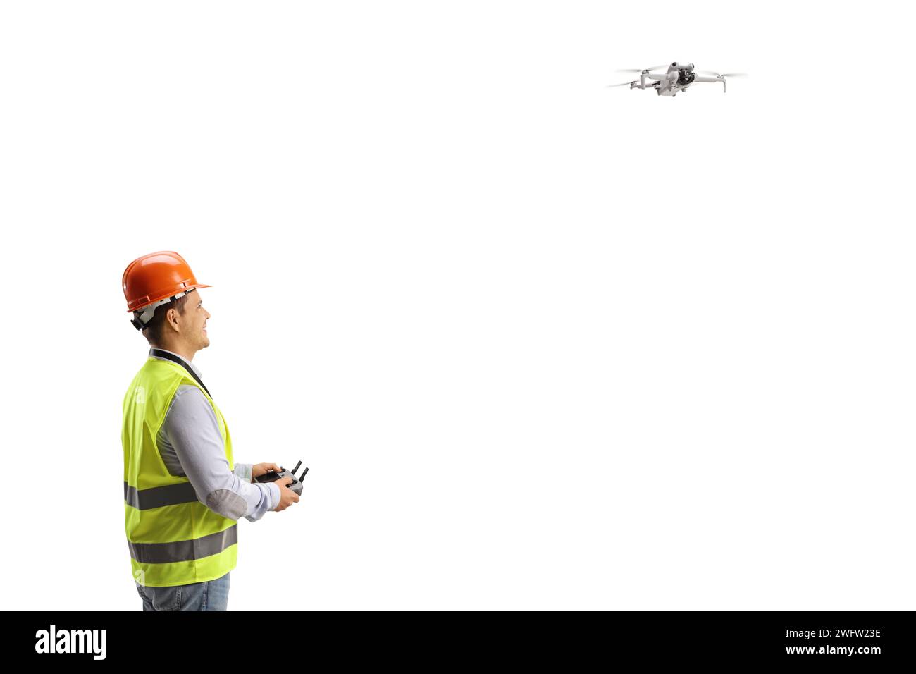Ein Ingenieur fliegt eine Drohne mit einer Fernbedienung auf weißem Hintergrund Stockfoto