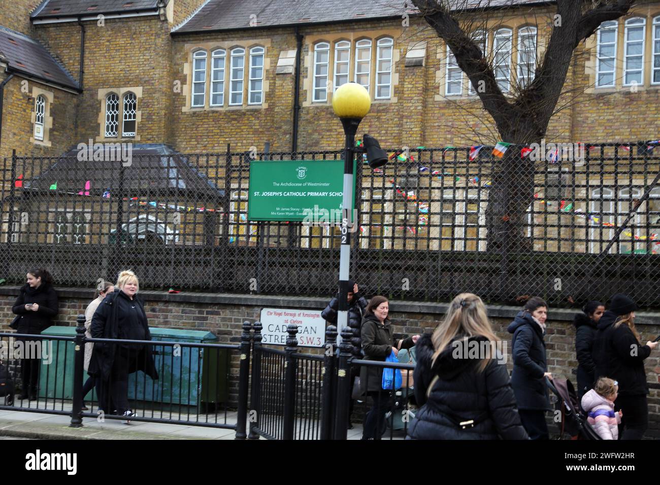 Eltern und Kinder vor der St. Joseph's Catholic Primary School Cadogan Street Chelsea London England Stockfoto