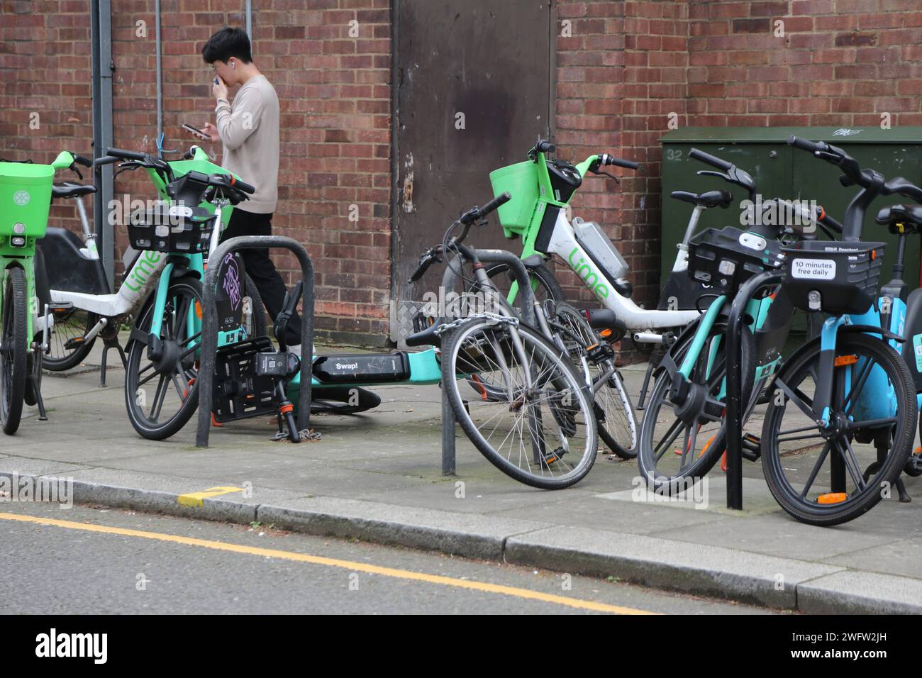 Tier-, Lime- und River-E-Bike-Verleih-System für Fahrräder ohne Dockless auf dem Asphalt Chelsea London England Stockfoto