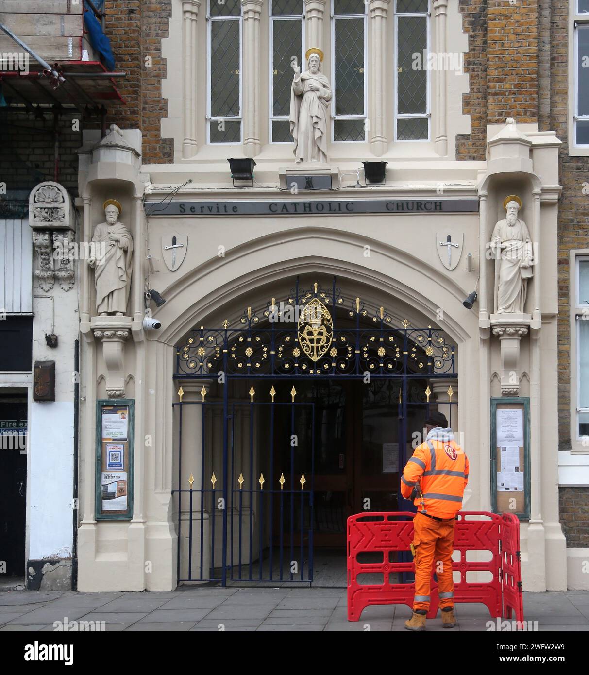Arbeiter vor dem Eingang der Servite Catholic Church (Our Lady of Dolours) Chelsea London England Stockfoto