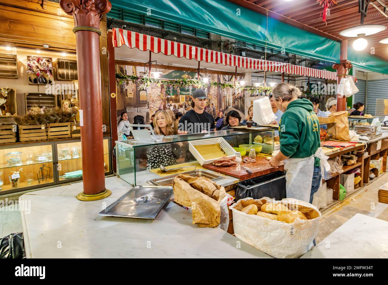 Ein Mann, der Sandwiches im Florence Mercato Centrale herstellt, einem belebten, beliebten Markt für frische Lebensmittel und Produkte in Florenz, Italien Stockfoto