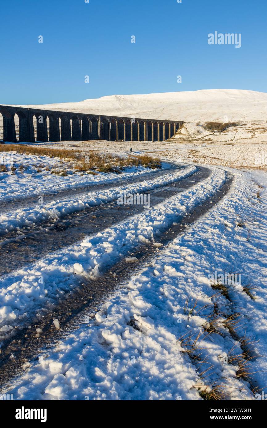 Das Ribblehead Viaduct an einem winterlichen Tag in den Yorkshire Dales in England, mit Whernside bedeckt mit Schnee im Hintergrund. An einem sonnigen Tag aufgenommen. Stockfoto