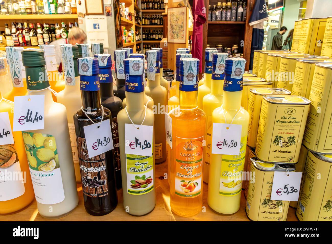 Flaschen mit Likören und Olivenöl werden an einem Marktstand im Florence Mercato Centrale angeboten, einem beliebten Markt für frische Lebensmittel und Produkte in Florenz, Italien Stockfoto
