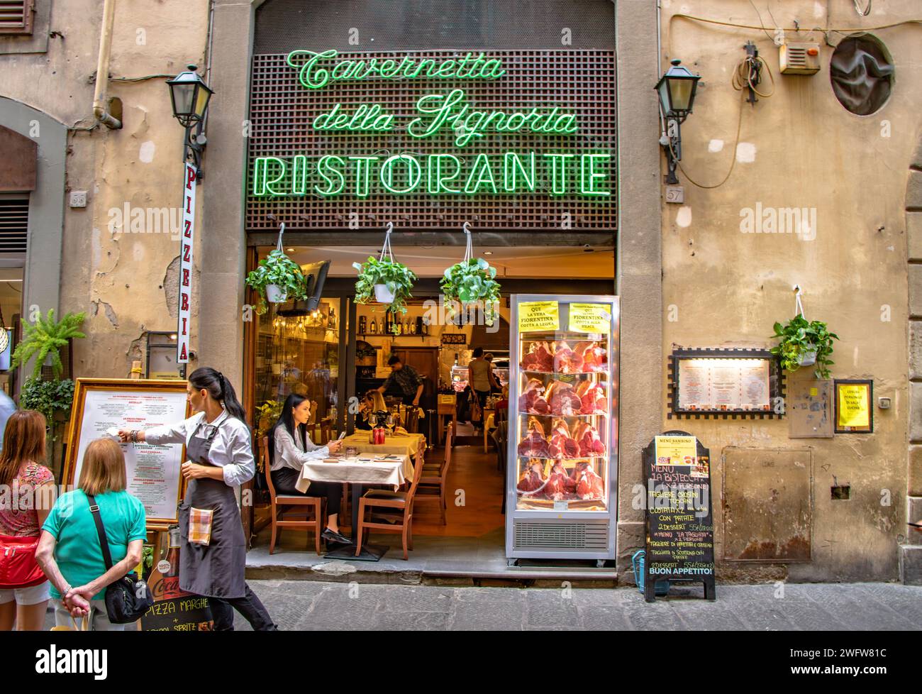 Leute, die das Menü vor der Tavernetta della Signoria lesen, einem florentinischen Steakrestaurant an der Via dei Neri, Florenz, Italien Stockfoto