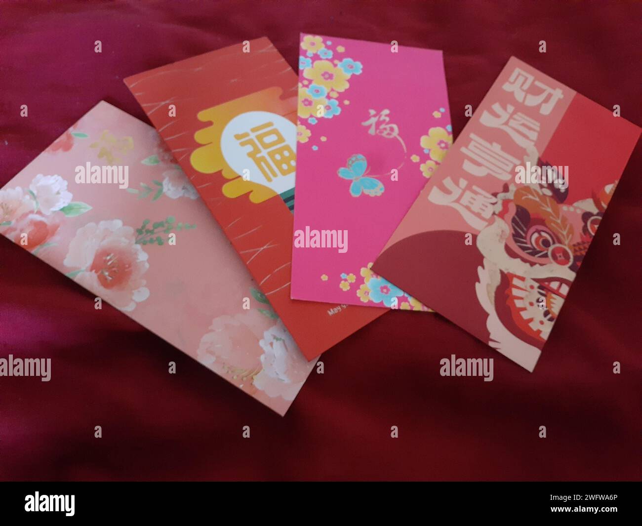 Vier chinesische Grußkarten mit orientalischem Hundedesign auf einem Bett Stockfoto