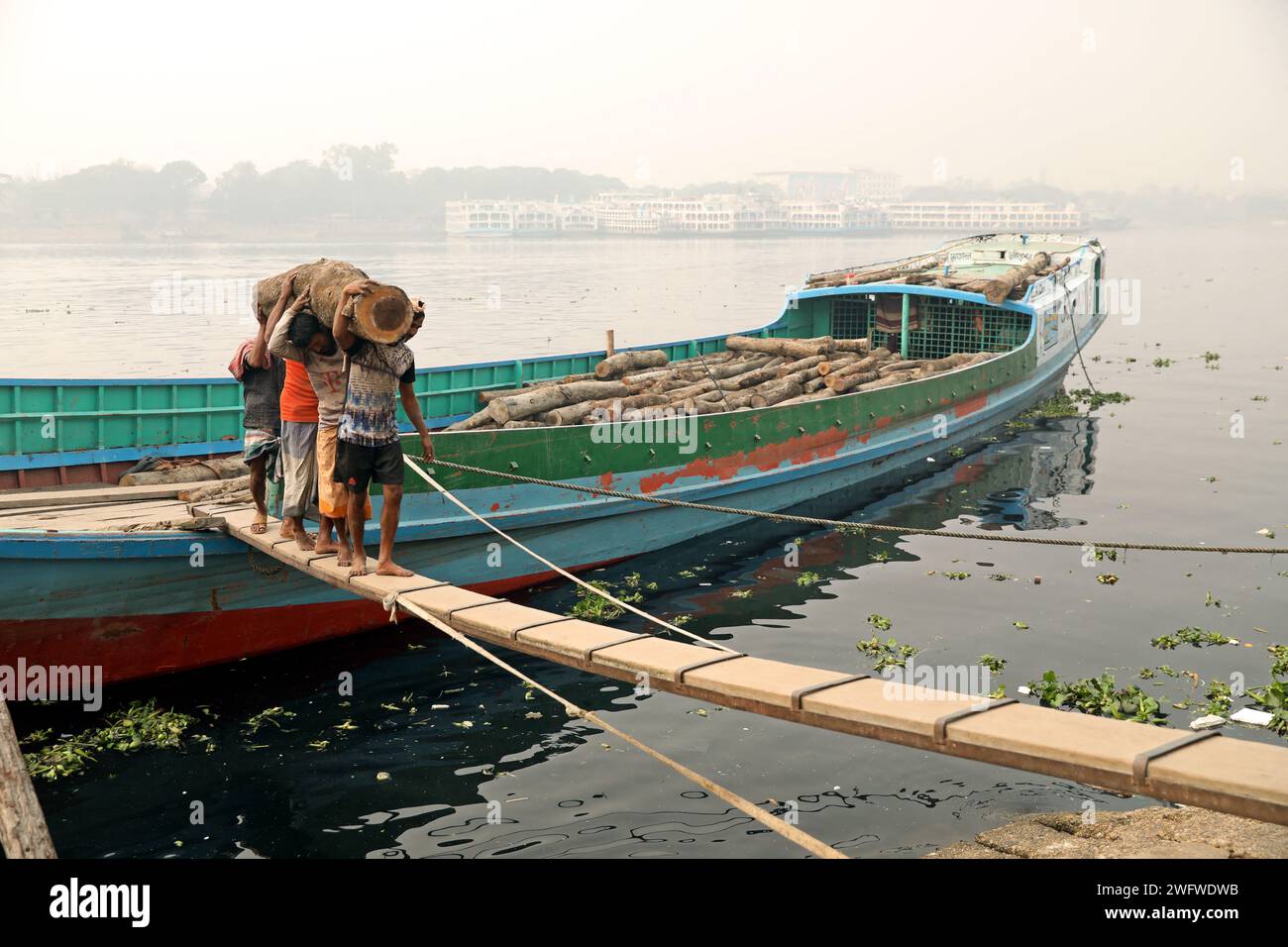 Dhaka, Bangladesch. Februar 2024. Arbeiter sortieren Holzscheite, die am 1. Februar 2024 von einem Boot am Ufer des Buriganga River in Dhaka entladen wurden. Foto: Habibur Rahman/ABACAPRESS.COM Credit: Abaca Press/Alamy Live News Stockfoto