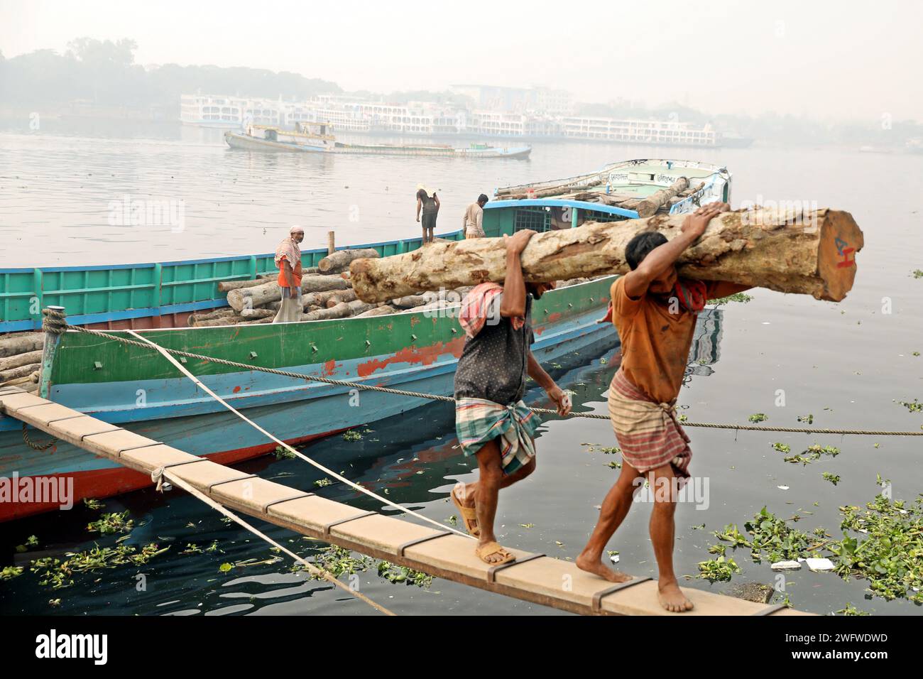 Dhaka, Bangladesch. Februar 2024. Arbeiter sortieren Holzscheite, die am 1. Februar 2024 von einem Boot am Ufer des Buriganga River in Dhaka entladen wurden. Foto: Habibur Rahman/ABACAPRESS.COM Credit: Abaca Press/Alamy Live News Stockfoto