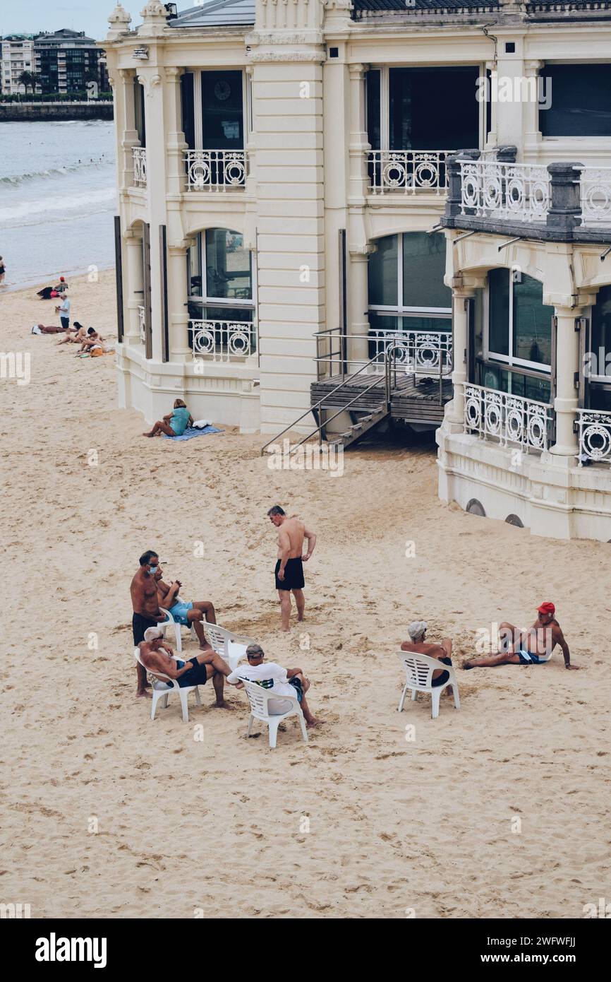 Ältere Männer entspannen am Strand von San Sebastian in Spanien am 21. Juni 2021 Stockfoto