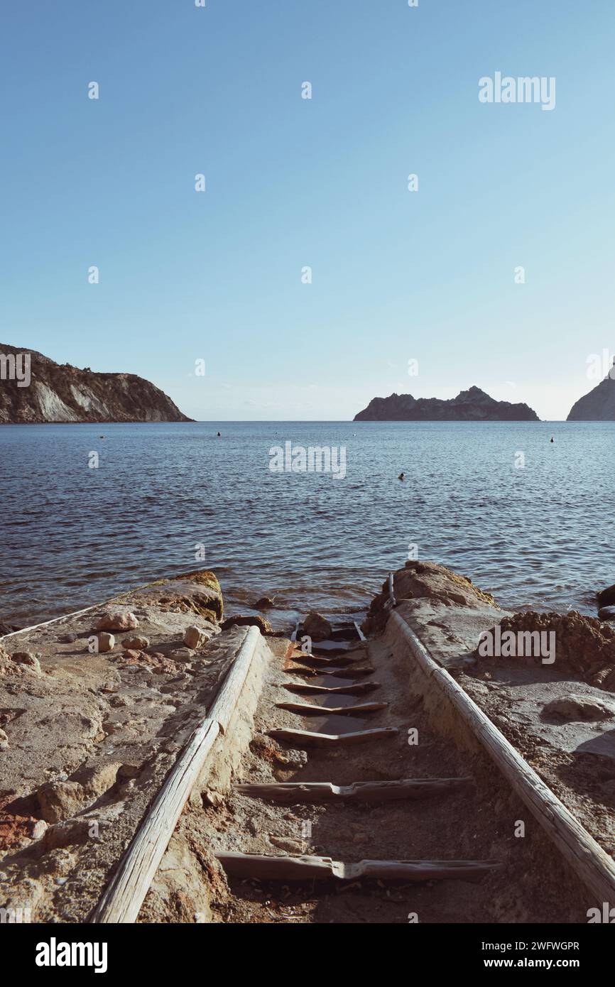 Schienen, die am 14. Februar 2023 an einem Strand in Ibiza in Spanien ins Meer einfahren Stockfoto