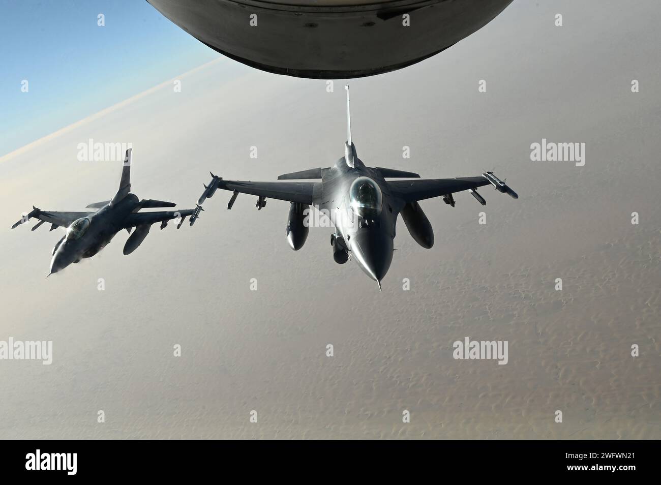 F-16 Fighting Falcons der US Air Force fliegen synchron nach dem Auftanken während der Übung Ballast Cannon 24,3 über einen nicht offengelegten Ort innerhalb des US Central Command Area of Responsibility, 7. Januar 2024. Als routinemäßige Übung, die fast vierteljährlich mit der Royal Bahraini Air Force durchgeführt wird, unterstützt diese Iteration die schnellen Expeditionsfähigkeiten der U.S. Air Force, indem sie Agile Combat Employment Objectives für F-16 Fighting Falcon, KC-135 Stratotanker und operatives Hilfspersonal integriert. Stockfoto