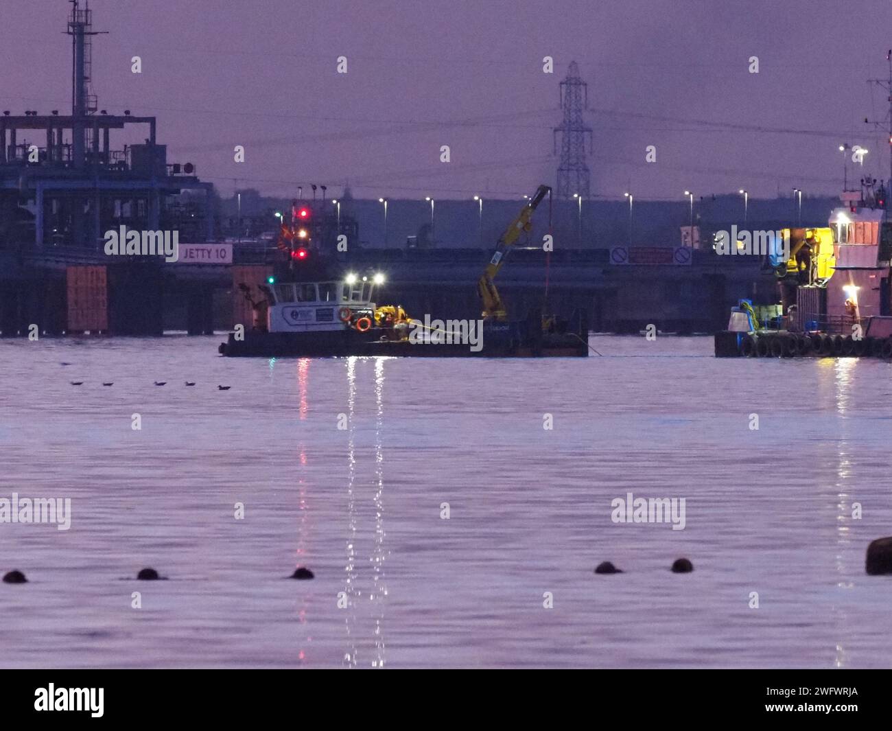 Queenborough, Kent, Großbritannien. Februar 2024. Drei Schiffe, die auf dem Medway gesehen wurden, um einen versunkenen Krankahn im Auftrag von Peel Ports London Medway zu bergen, fotografiert aus Queenborough, Kent. Quelle: James Bell/Alamy Live News Stockfoto