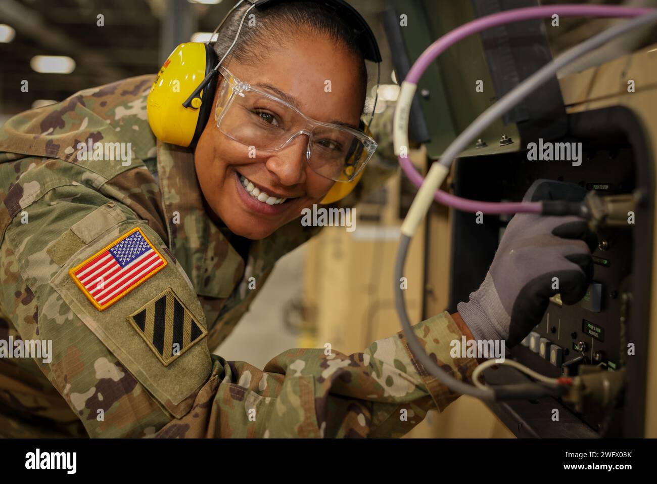 Staff-Sgt. Jasmine N. Barnes lächelt die Kamera an, während er am 29. Januar 2024 an einem 60-kW-AMMPS-Generator arbeitet, MEP-1070. Stockfoto