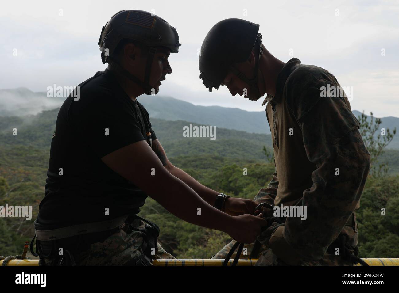 Irving Gomez, Left, ein Ausbilder am Jungle Warfare Training Center, bereitet einen Marine vor, während eines Basic Dschungle Skills Kurses am JWTC in Camp Gonsalves, Okinawa, Japan, am 9. Januar 2024 abzuseilen. BJSC vermittelt Marines grundlegende Überlebensfähigkeiten im Dschungel, taktische Seilhängetechniken und Kampftaktiken im Dschungel, um die Letalität in rauen Dschungelumgebungen zu verbessern. Gomez stammt aus Texas. Stockfoto