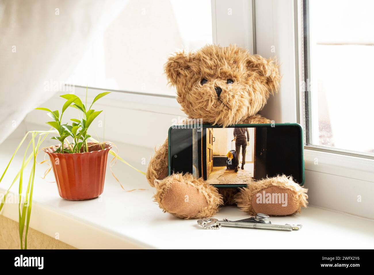 Eine ukrainische Frau kommt aus dem Eingang mit einem Koffer und der Flagge der Ukraine, Flüchtlinge aus der Ukraine während des Krieges, Foto auf dem Telefonbildschirm o Stockfoto