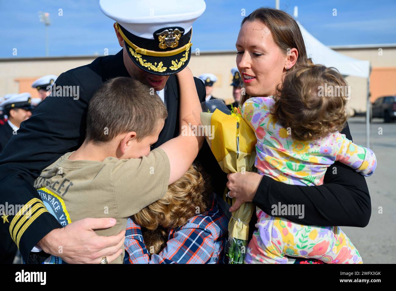 Cmdr. Jeremiah Daley, Befehlshaber der Unmanned Surface Vessel Division One (USVDIV-1), umarmt Familienmitglieder nach der Rückkehr zum Heimatflughafen Ventura County in Port Hueneme, Kalifornien, und dem Abschluss des integrierten Kampfproblems (IBP) 23.2, 15. Januar 2024. IBP 23,2 ist eine Übung der pazifischen Flotte zum Testen, entwickeln und Evaluieren der Integration unbemannter Plattformen in den Flottenbetrieb, um Vorteile der Kriegsführung zu schaffen. Stockfoto