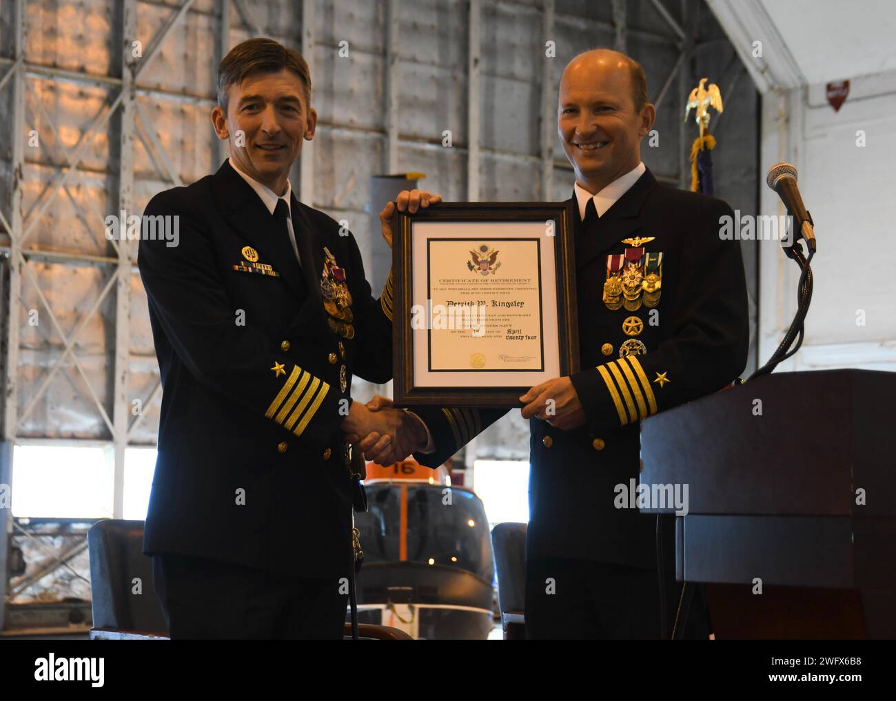 NAS PATUXENT RIVER, Maryland (10. Januar 2024) – Kapitän Derrick Kingsley, verlassen, erhält seine Bescheinigung über den Ruhestand von Kapitän Douglas Burfield bei der NAS Patuxent River Change of Command Zeremonie am 10. Januar. Burfield übernahm das Kommando über die Flugstation von Kingsley, die nach 27 Jahren Marinedienst in den Ruhestand ging. Stockfoto