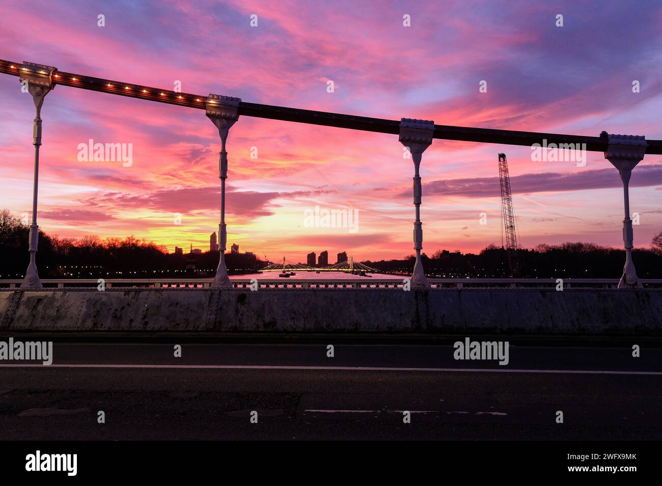 London, Großbritannien. Februar 2024. Ein herrlicher Sonnenuntergang mit lebhaften Farben aufgrund der sich in der Sahara ablagernden Staubablagerungen, von der Chelsea Bridge aus gesehen. Quelle: Eleventh Photography/Alamy Live News Stockfoto