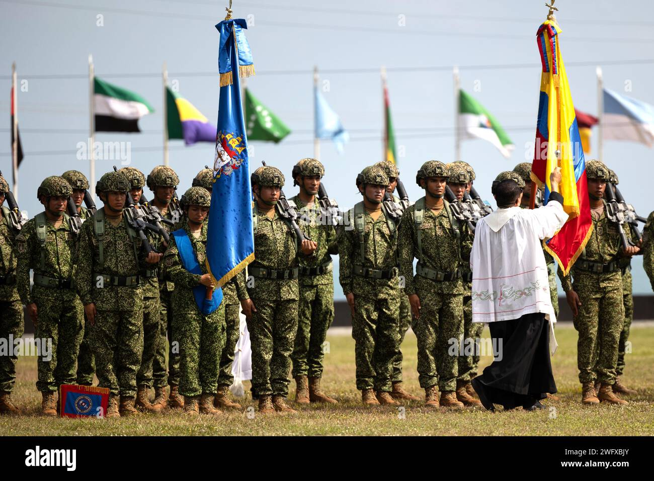 Lokale kolumbianische religiöse Führer segnen die Infantes de Marina de Colombia (kolumbianische Marines) während der Rekruten-Vereidigung in der Base de Entrenamiento de Marina in Coveñas, Kolumbien, 11. Januar 2023 mit Weihwasser. Zum ersten Mal in der kolumbianischen Geschichte absolvierten 60 Frauen das Juramento de Bandera de Infantes de Marina, nachdem sie drei Monate lang Rekrutierungstraining absolviert hatten und sich in die Reihen der kolumbianischen Marineinfanterie eintraten. Die US-Marines nahmen an der Zeremonie Teil, um Solidarität zu zeigen und den bedeutenden Beitrag der Partnerländer zu den Prinzipien von Frauen, Frieden und Sicherheit zu unterstützen Stockfoto