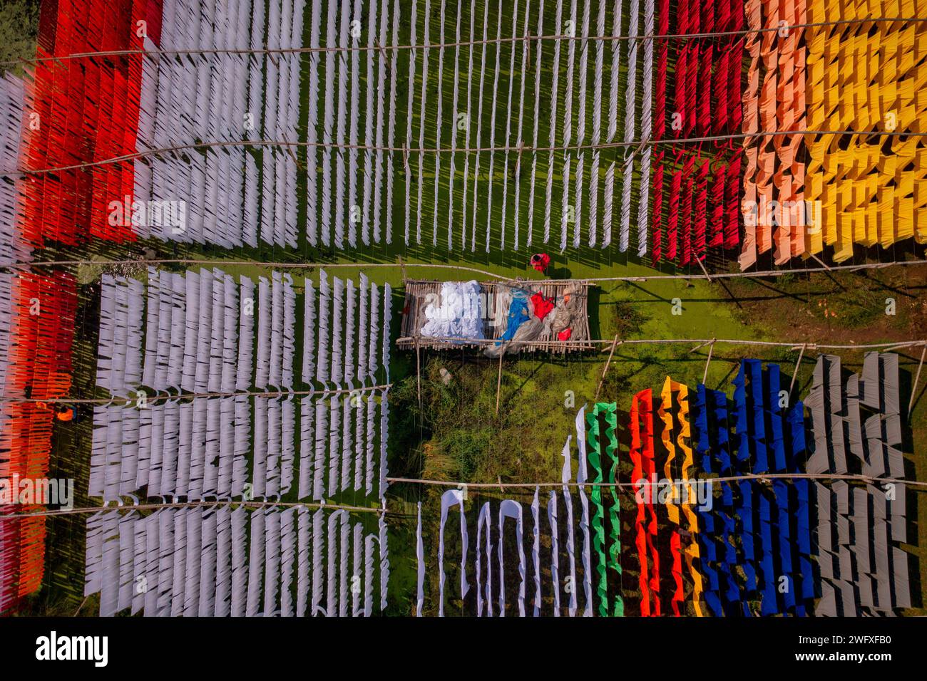 Aus der Vogelperspektive von Menschen, die in einer öffentlichen Wäscherei arbeiten, die zum Trocknen von bunten Stoffen in Narayanganj, Dhaka, Bangladesch hängend sind. Stockfoto