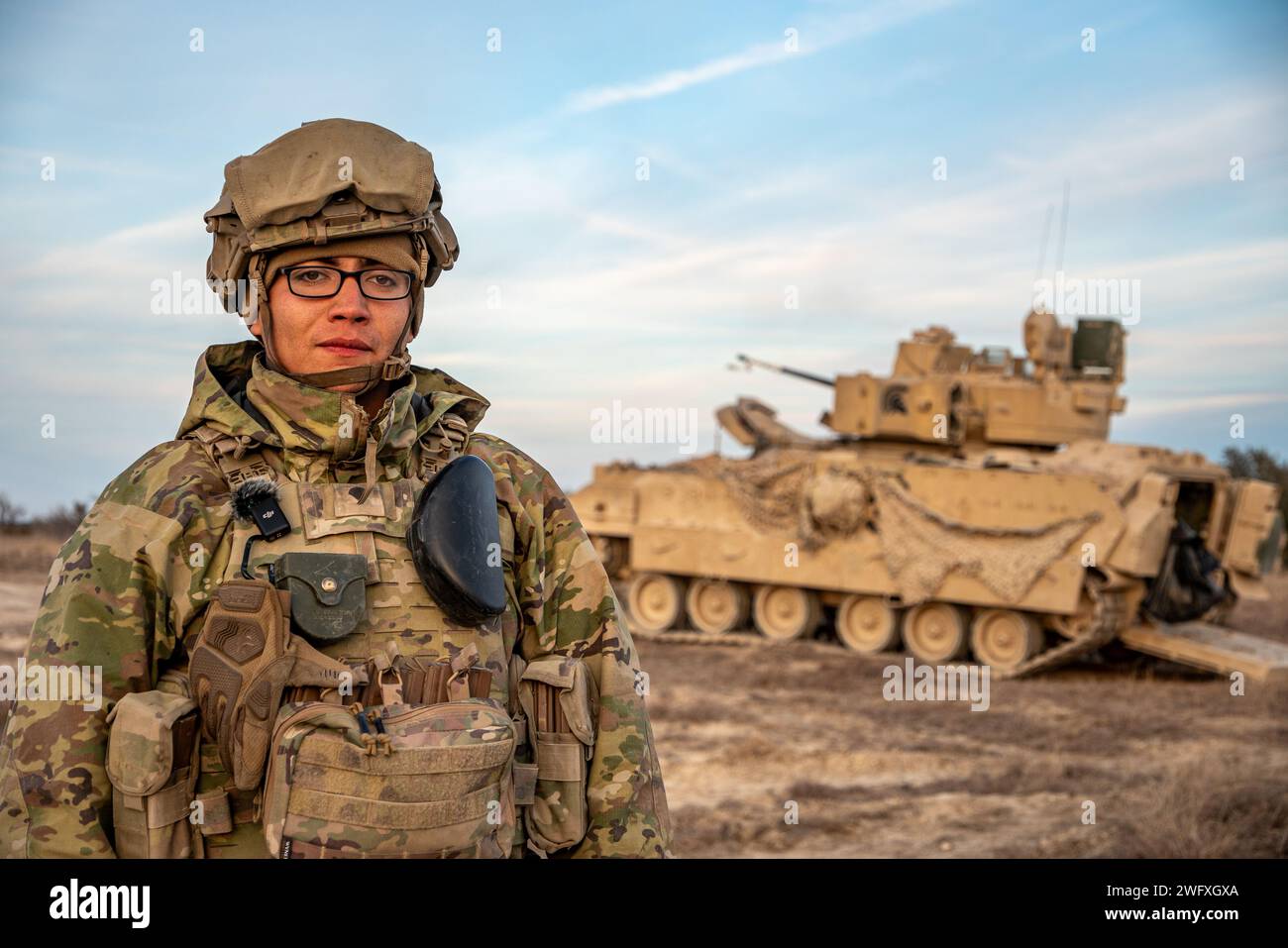 SPC. Alejandro Mejia, ein Infanterie-Mann, der dem 1. Bataillon, 12. Kavallerieregiment, 3. Panzerbrigade Combat Team, 1. Kavalleriedivision, zugeteilt ist, posiert vor einem Bradley-Kampffahrzeug während einer Live-Feuerübung (CALFEX) auf Fort Cavazos, Texas, 20. Januar 2024. CALFEX hilft, Truppen und Einheiten zu trainieren, indem es Teamzusammenhalt durch rigorose und realistische Kampfszenarien schafft. Stockfoto