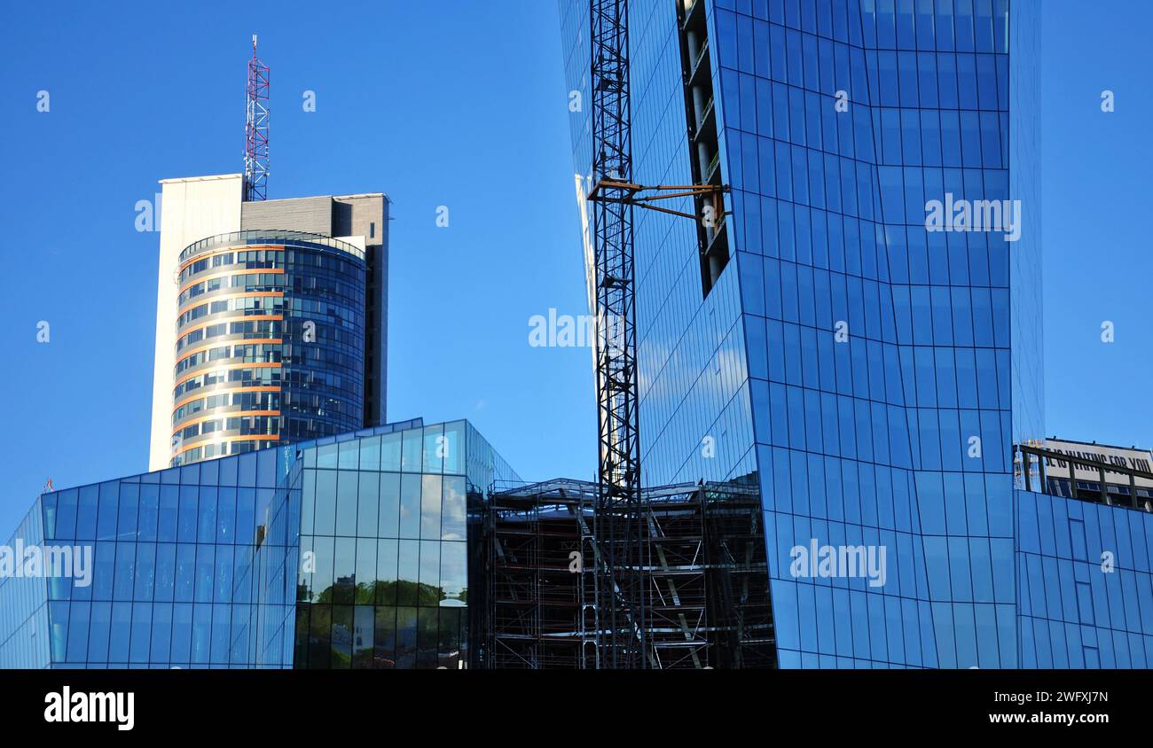 Vilnius (Litauen): Moderne Glashochhäuser im Bau. Ungewöhnlicher Aufnahmewinkel. Klarer Himmel, Reflexionen in den Fenstern Stockfoto