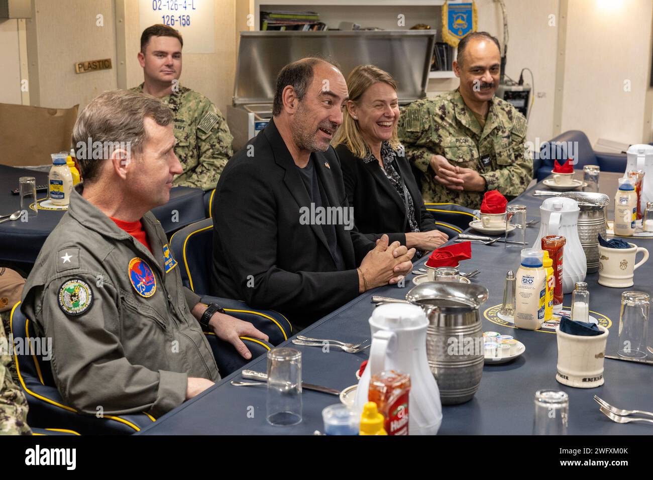 SINGAPUR – USA Botschafter in Singapur Jonathan E. Kaplan, Zentrum und hinterer ADM. Mark Melson, links, Kommandant der Task Force 73, sprechen mit der Führung an Bord der USS Stethem (DDG 63) während eines Schiffsbesuchs in Sembawang Wharves, Singapur, 10. Dezember. Stockfoto