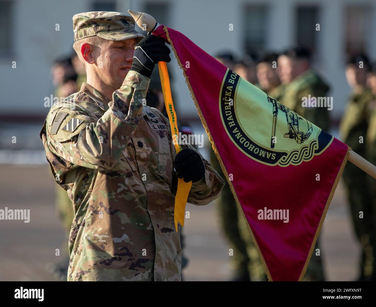 Oberstleutnant Timothy W. Decker, Befehlshaber der NATO-Kampfgruppe Polen und Befehlshaber des 2. Bataillons, 69. Panzerregiment „Panther Battalion“, 2. Panzerbrigade Combat Team, 3. Infanteriedivision, bringt einen Streamer an der Leitlinie für das 12. kroatische Kontingent „Eiserne Eber“ an, während der Übertragung der Autorität zwischen dem ausscheidenden 12. kroatischen Kontingent „Eiserne Eber“ und dem eingehenden 13. kroatischen Kontingent „Eiserne Eber“ in Bemowo Piskie, Ausbildungsgebiet, Polen, 29. Januar 2024. Die Mission der 3rd Infantry Division in Europa besteht darin, sich an multinationalen t zu beteiligen Stockfoto